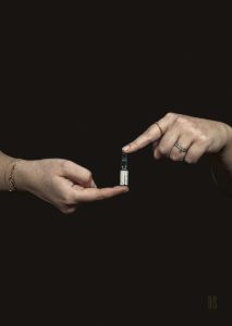 two hands balance a via of clear medicine