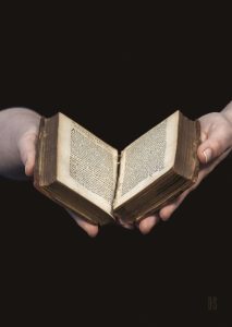 two hands delicately holding an old Petrarch 1577 book