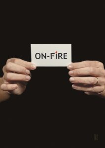 two hands holding a card with On-fire written on it