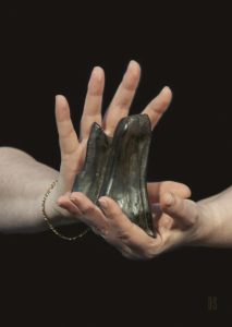 two hands holding a piece of bog oak from Ireland