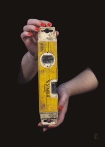 two hands holding a yellow spirit level