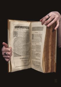 two hands holding up a large old French and English dictionary
