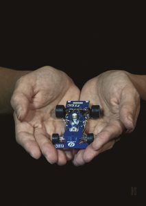 two hands holding a formula one car toy